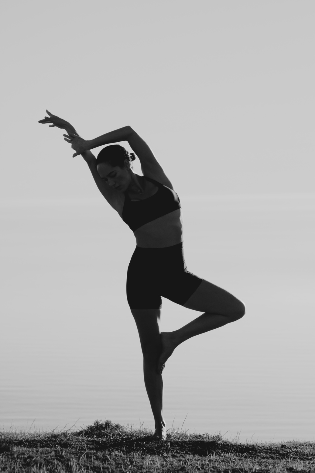 Yoga practitioner in a balanced pose by the water